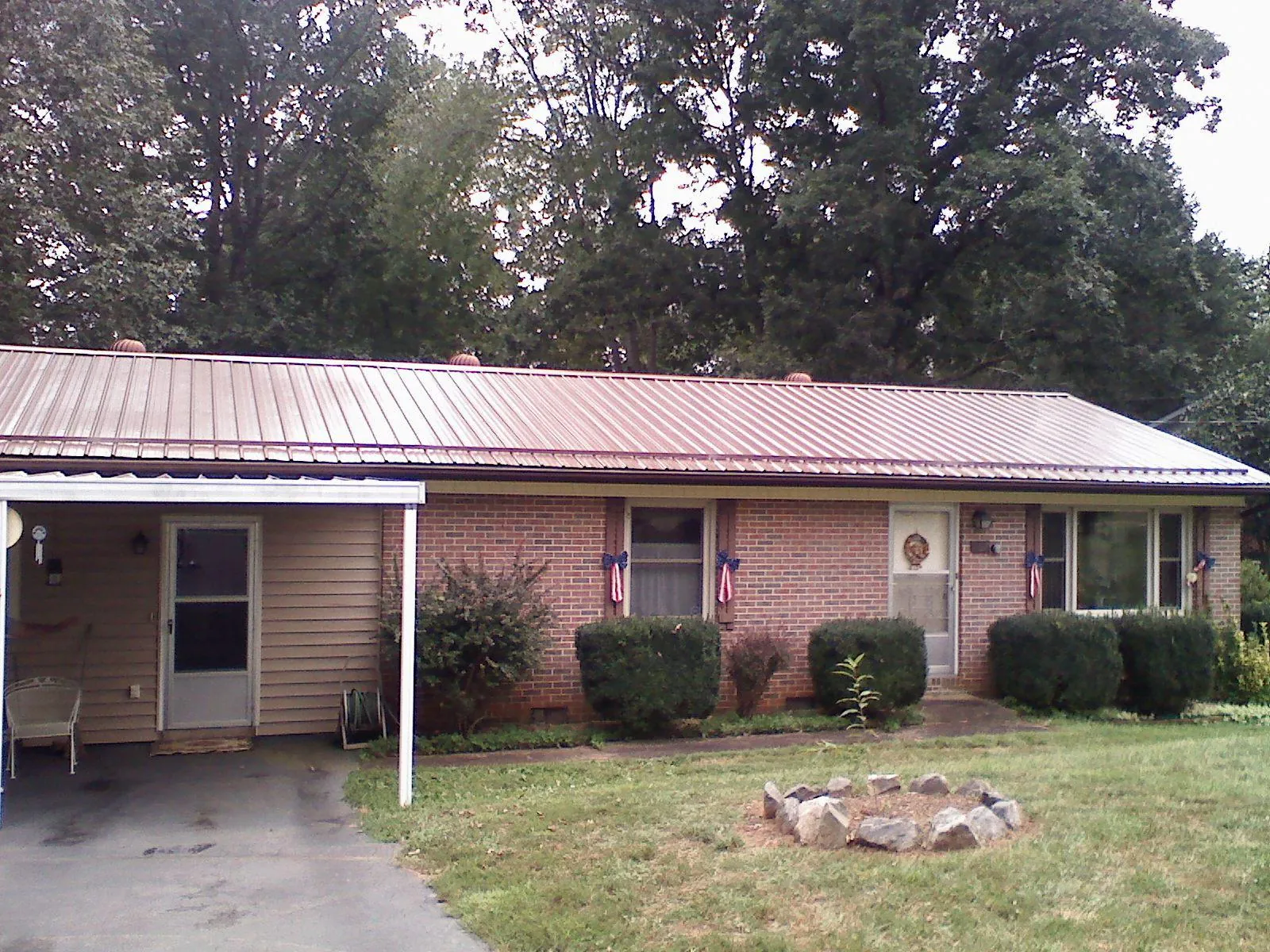 Bronze metal roof and carport on a brick ranch home — Roof Repair work by our crew in Mulberry